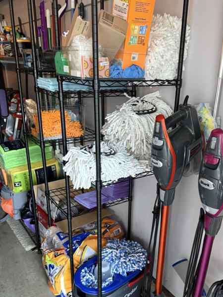 Wire rack of mops, microfiber cloths, and Shark vacuums